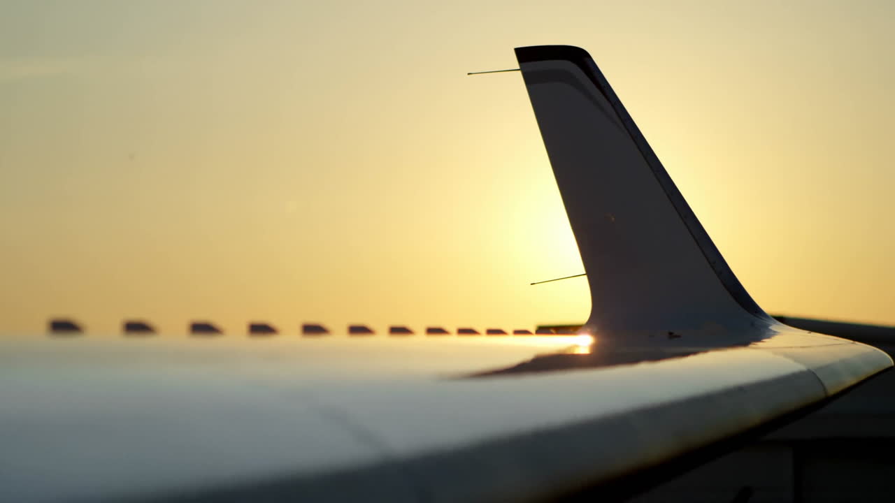 Reflecting sunlight, airplane wing during golden hour, creating serene atmosphere