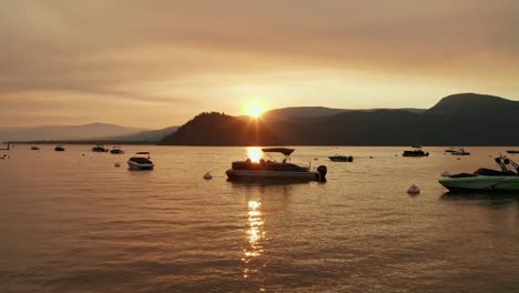 Paisaje-Aéreo-Lento-A-Través-Del-Lago-Canadiense-Con-Barcos-Atracados-Durante-La-Hermosa-Puesta-De-Sol