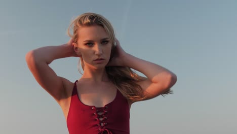 young blonde girl playing with her hair at the beach