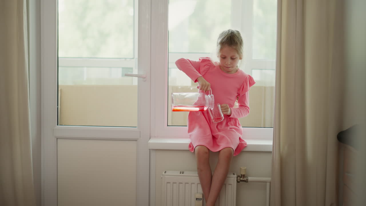 Girl pouring juice on the windowsill