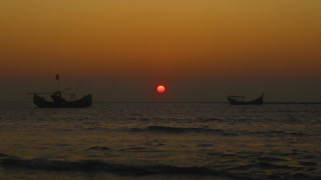 황금 시간 동안 바다에 정박된 어선의 실루엣