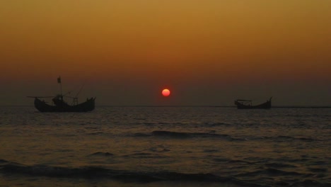 silhouette of fishing boats parked on sea during golden hour