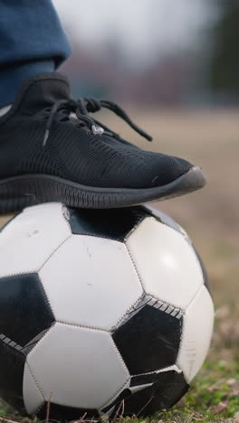 close-up of a person shifting their foot from left to right on a soccer ball, with a grassy field and blurred background