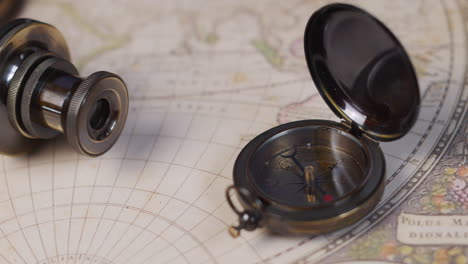 vintage compass and telescope on ancient world map