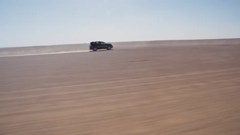vehículo 4x4 que conduce muy rápido a través de la arena seca y polvorienta del desierto del sahara