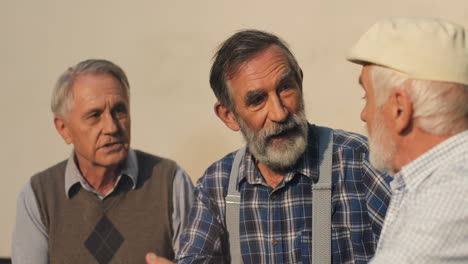 Close-Up-Of-The-Three-Old-Retired-Men-Neighbors-Disputing-While-Sitting-And-Resting-On-The-Bench-On-A-Sun