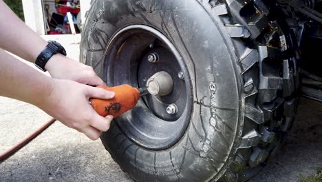 usando una llave de impacto para apretar las tuercas