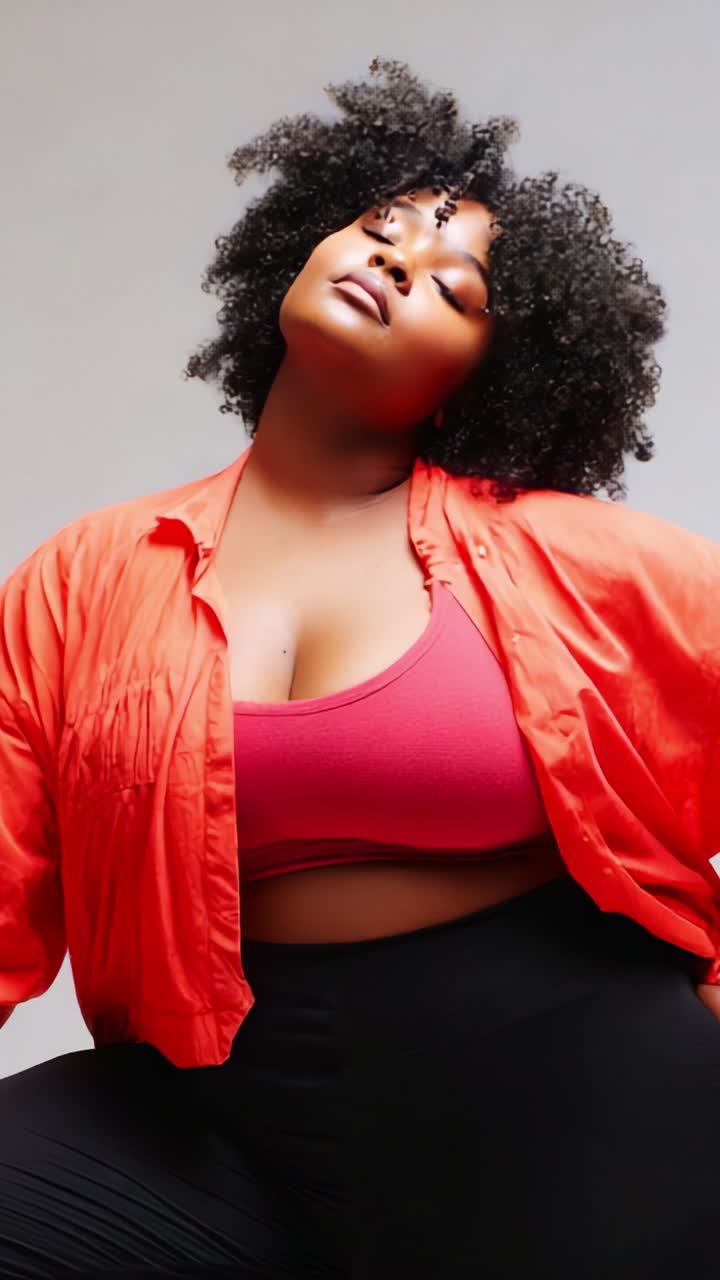 Confident Model Poses in Vibrant Red Shirt and Stylish Outfit, Capturing Grace and Empowerment in a Fashion-Forward Photoshoot with Creative Lighting