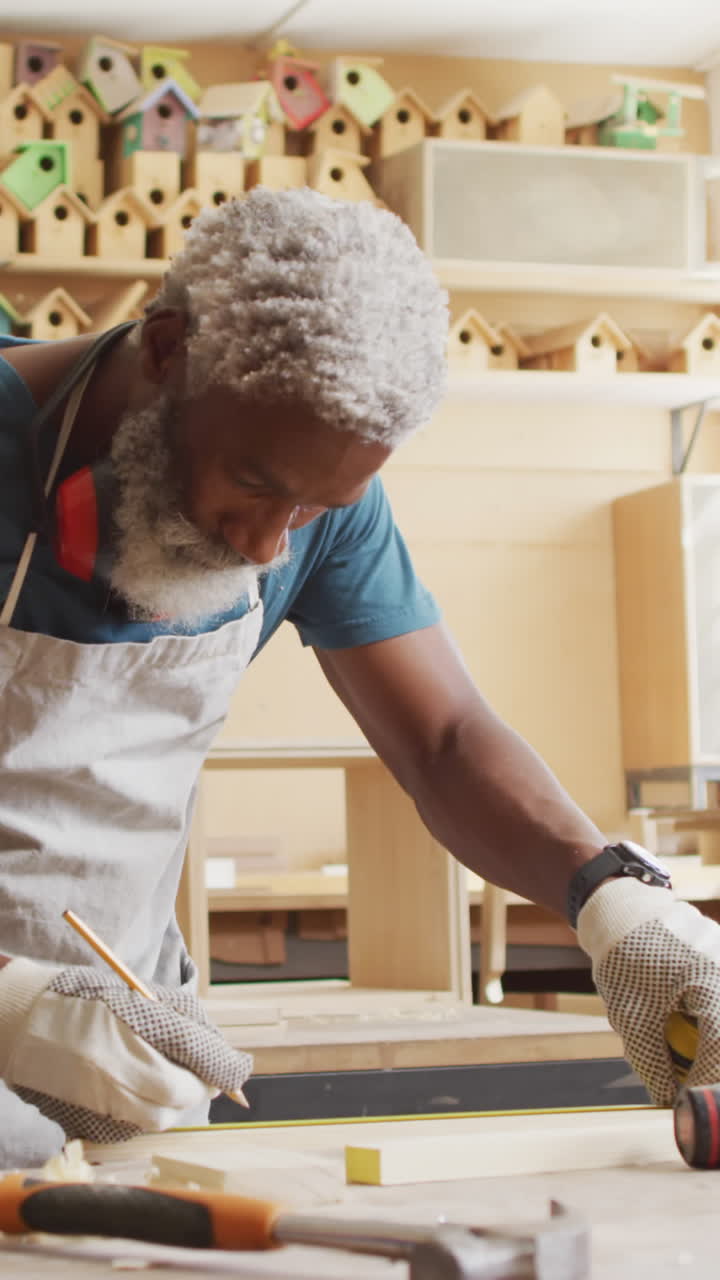 Artesão afro-americano medindo madeira em uma oficina.