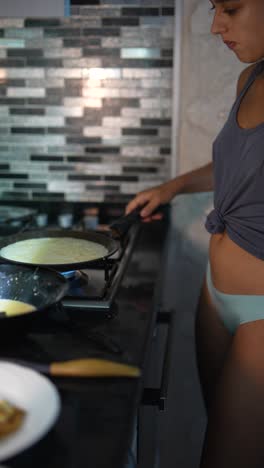 mujer cocinando panqueques en una cocina