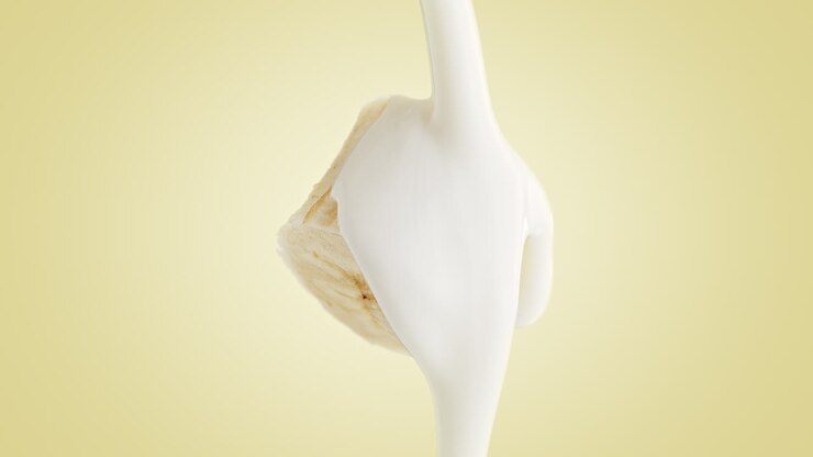 yogur cremoso encima de un plátano en rebanadas suaves en un fondo amarillo en cámara lenta macro