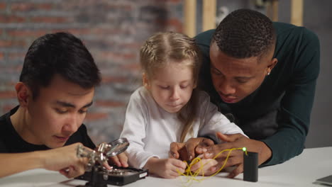 Girl-with-teacher-connect-cables-of-lamp-man-learns-HDD