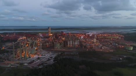 Drone-shot-flying-towards-metal-factory-at-dusk