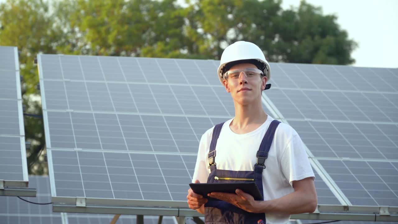 Solar panel technician working with solar panels. Engineer in a uniform with a tablet checks solar panels productivity. The green energy concept