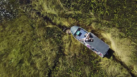 man trying to free a motor boat in a swamp