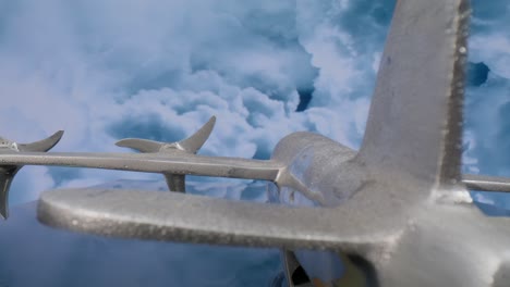 vista macro de lente de modelo de avión plateado desde la parte trasera con nubes en el fondo y video moviéndose en