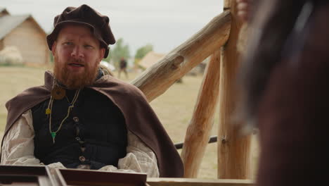 squire talks to woman in courtyard in medieval village