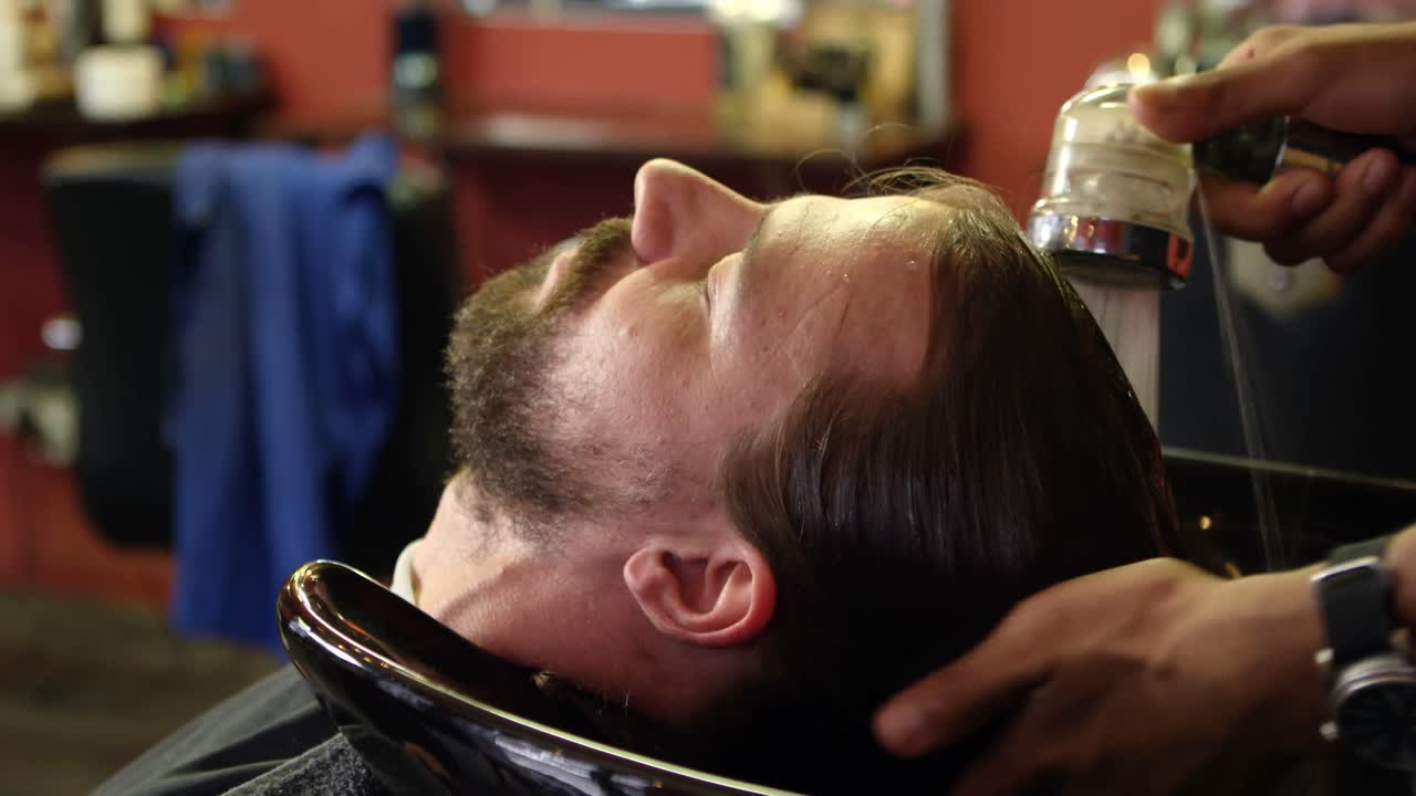 el hombre se está lavando el cabello.