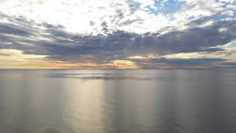 antena: toma de pedestal ascendente del horizonte y cielo nublado cúmulo con mar báltico en calma