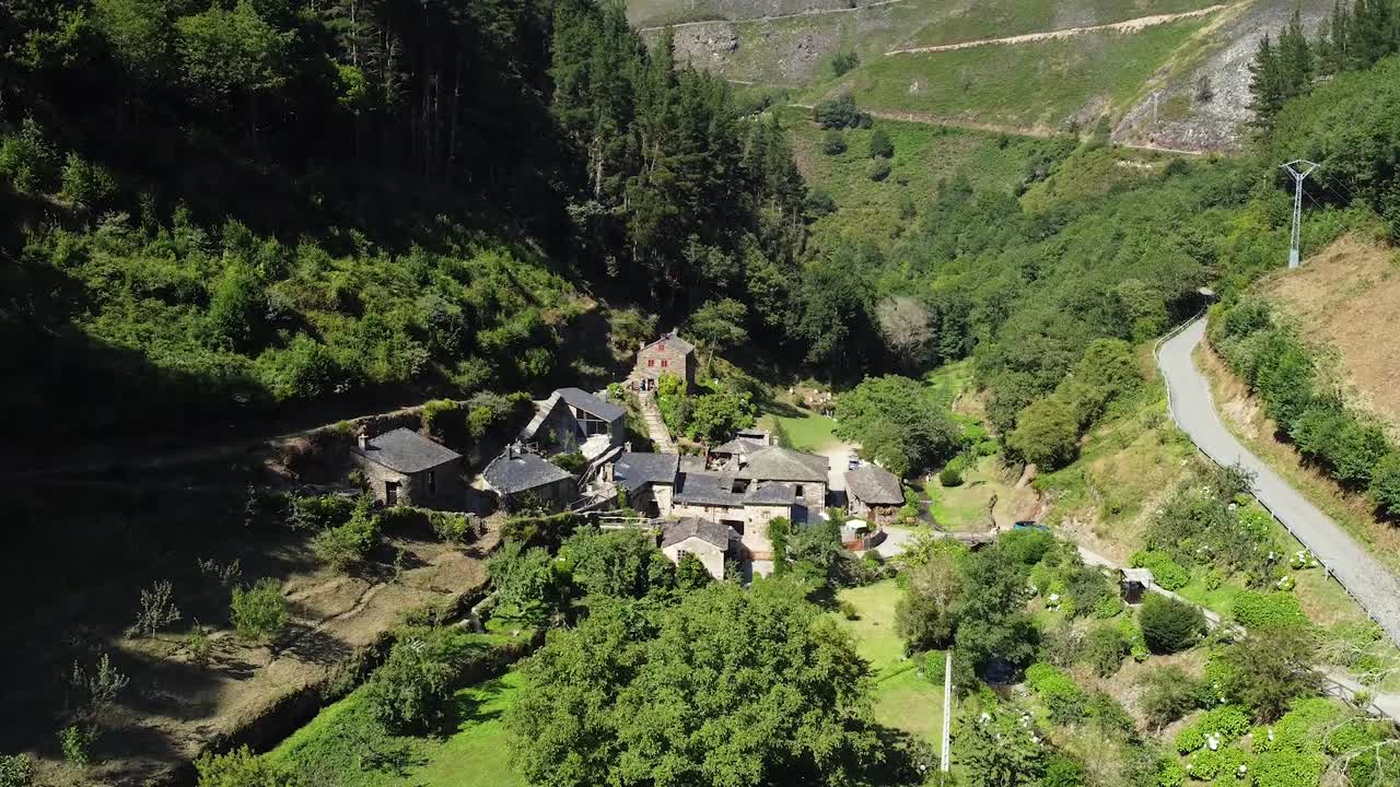 스페인 아스투리아스의 녹색 산 계곡에 있는 작은 마을에 매우 가까워지는 드론의 공중 촬영