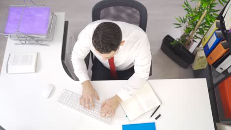 Businessman-is-using-computer-at-his-desk-in-the-office.