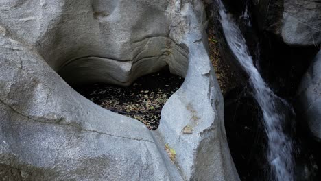 drone view of heartrock in crestline california - natural rock formation with flowing waterfall