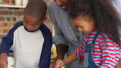 Father-And-Children-Baking-Cakes-In-Kitchen-Together