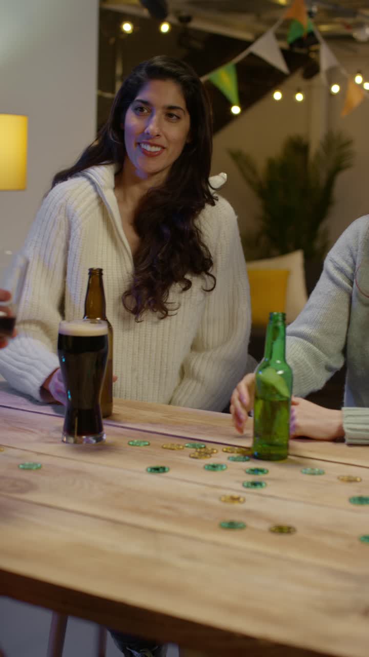 video vertical de un grupo de amigos en casa o en un bar celebrando en la fiesta del día de san patricio bebiendo alcohol y haciendo aplausos juntos 1