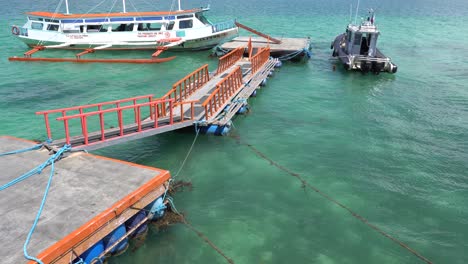 Tourist-Boat-Anchored-On-The-Blue-Ocean-Near-The-Floating-Dock-In-Puerto-Princesa,-Palawan,-Philippines