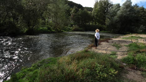 romanian girl looks at the water from the river bank 2