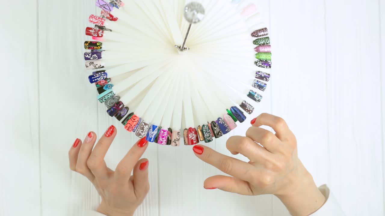 manos girando muestras de uñas.