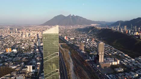 great building in the middle of the city of the mountains and below it many cars in the distance you see a great hill and a great metropolis