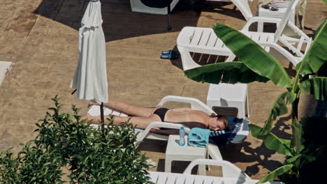 beautiful young women relaxing on the deck chair near the pool