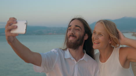 hombre y mujer posando para una selfie en la playa