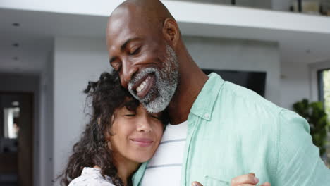 Happy-biracial-couple-holding-hands-and-dancing-in-living-room,-slow-motion