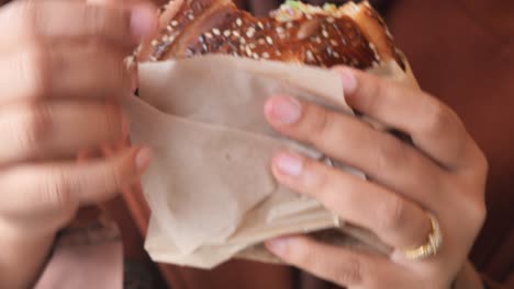 포장 된 샌드위치를 들고 있는 사람의 손의 클로즈업