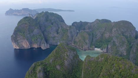 aerial view above the lush limestone rock formations in the andaman sea of ko phi phi leh looking towards the ko phi phi don islands at sunset with no tourists in sight