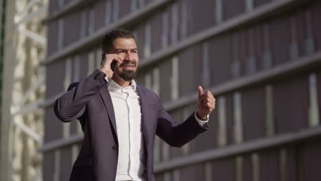 hombre de negocios emocional hablando por teléfono inteligente y gestos