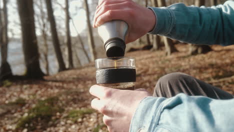 closeup of man pouring coffee in his cup on a sunny autumn day