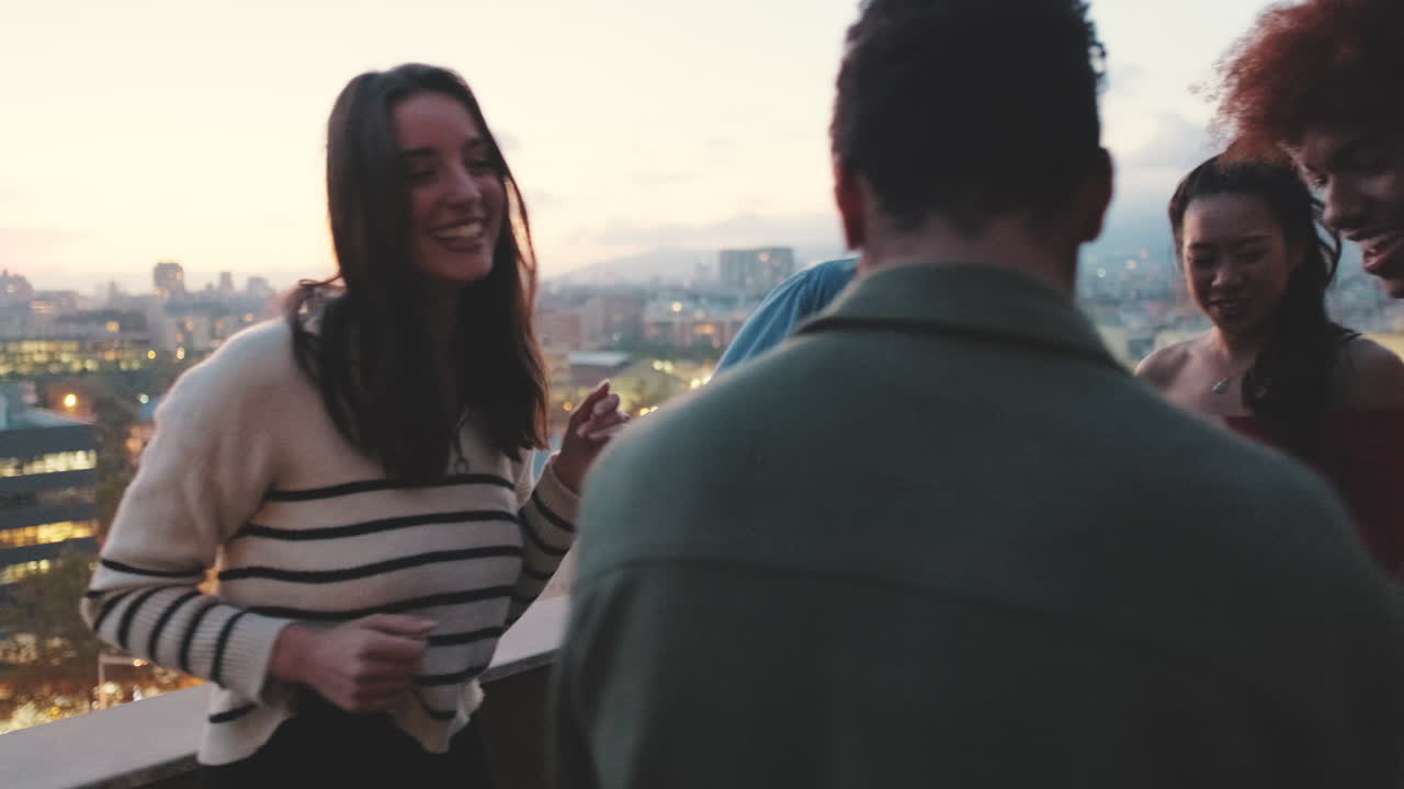 Amici che si godono una festa su un tetto al tramonto