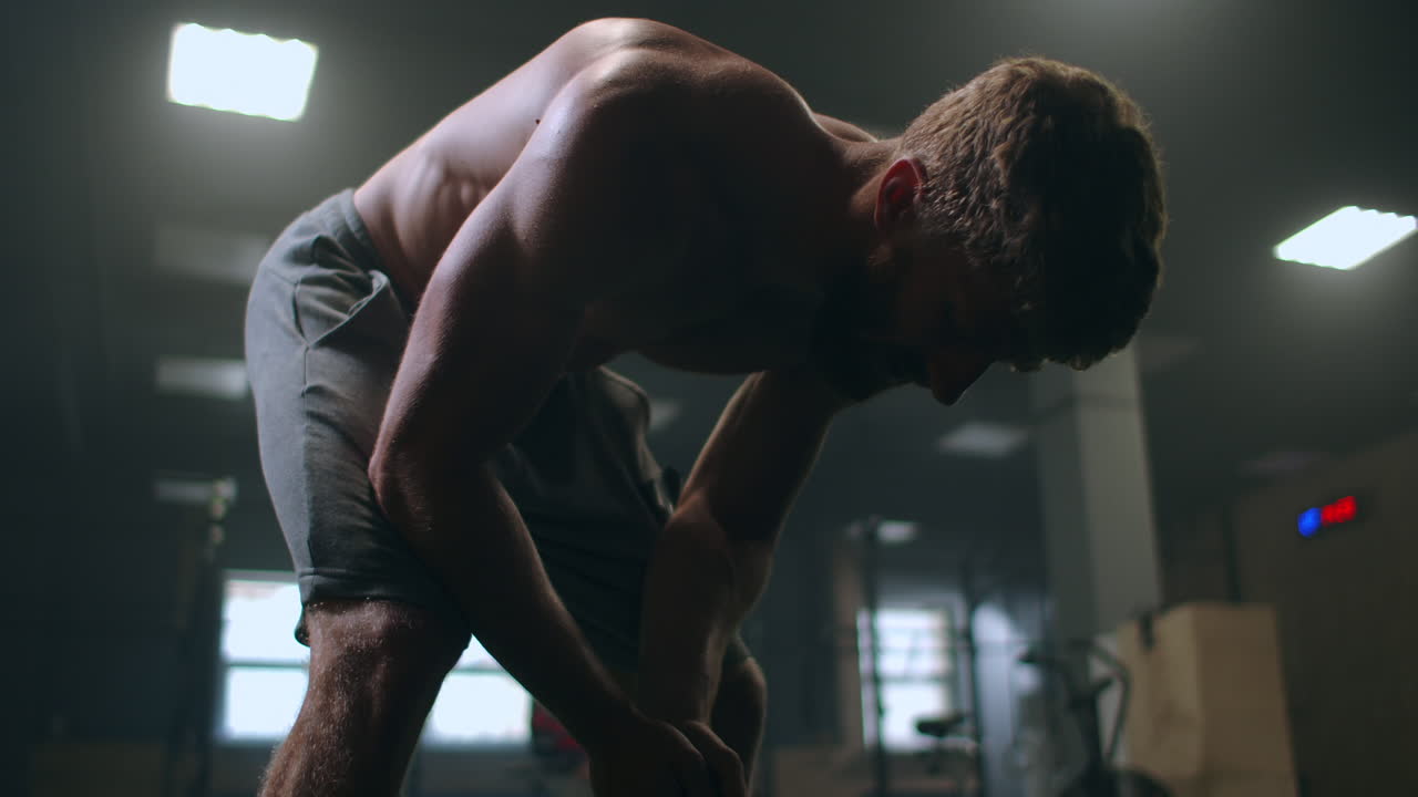 손으로 무 ⁇ 을  ⁇ 고 숨을  ⁇ 고 회복하고 있는 피곤한 남자