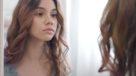 Beautiful-woman-putting-on-contact-lenses-at-mirror-in-home-bathroom