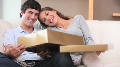 mujer morena abriendo un regalo con su novio