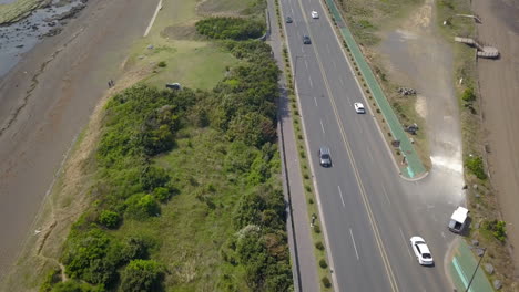 overhead drone shot of cars on an highway on jeju island, south korea.