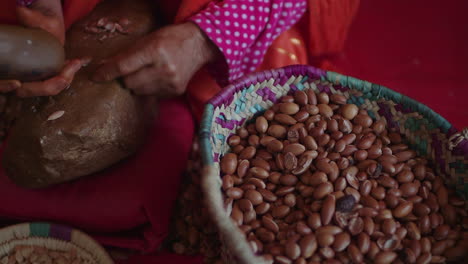 Close-up-of-old-woman-crushing-argan-nuts-with-a-rock-for-seeds