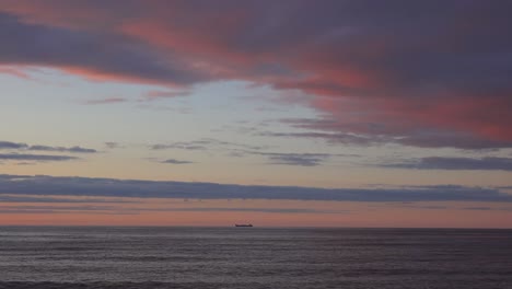 Un-Carguero-Muy-Distante-En-El-Horizonte-Al-Atardecer.