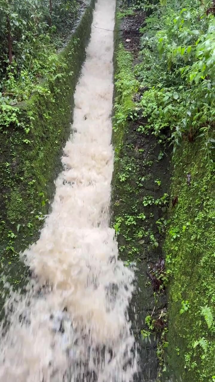 Scatto verticale di acqua piovana abbondante che sgorga attraverso uno storico scarico coloniale britannico a Nainital, India