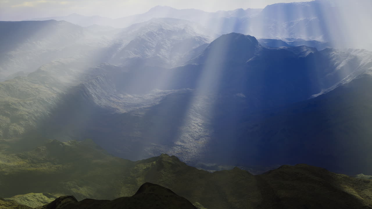 Misty mountain landscape with sun rays illuminating the valleys