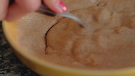 close up pf woman combining the ingredients in a bowl to form a batter