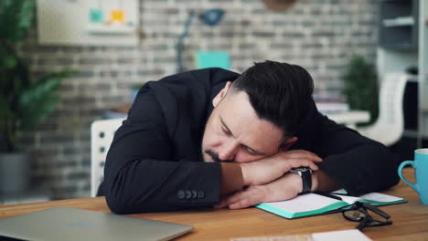un hombre de negocios cansado durmiendo en su escritorio.